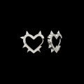 Love Kills spiked heart stainless steel earrings on a black background