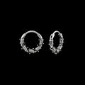 Barbed wire stainless steel hoop earrings on a black background