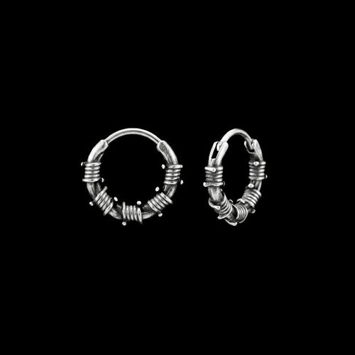 Barbed wire stainless steel hoop earrings on a black background