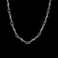 Barbed wire stainless steel necklace on a black background
