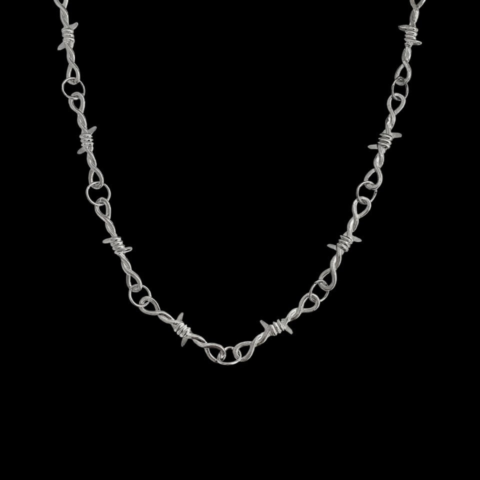 Barbed wire stainless steel necklace on a black background