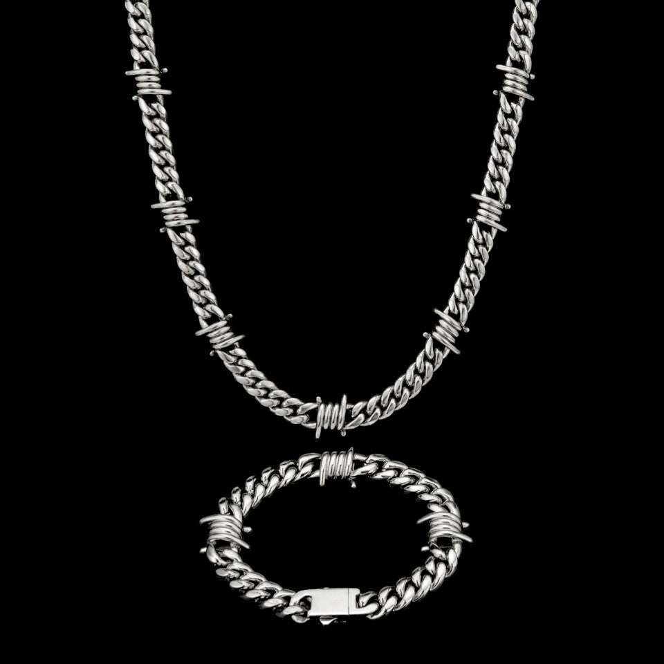 Barbed Cuban stainless steel jewelry set on a black background