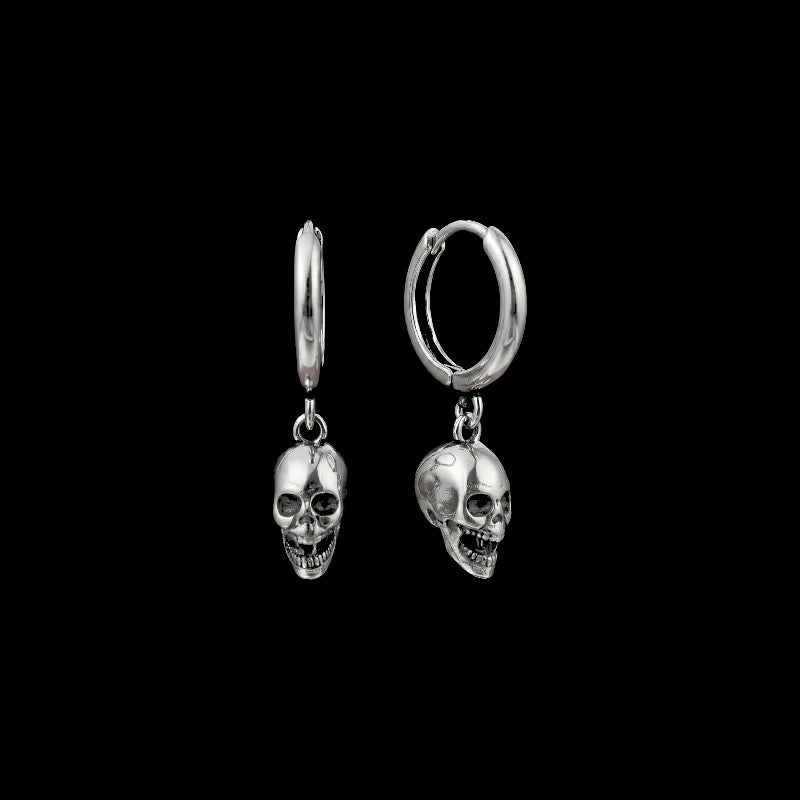 Death skull stainless steel hoop earrings on a black background