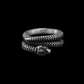 Coiled serpent stainless steel ring on a black background