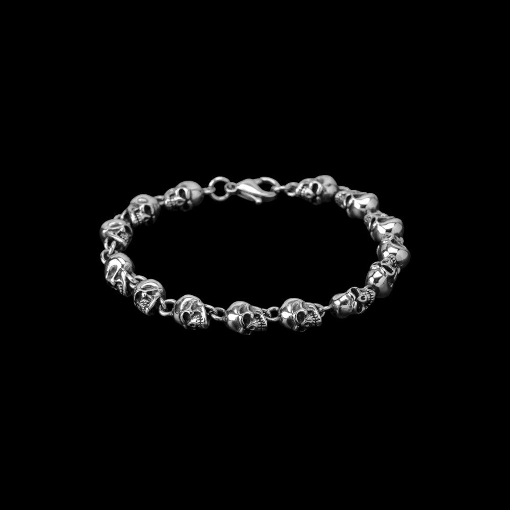 Bone stainless steel skull bracelet on a black background