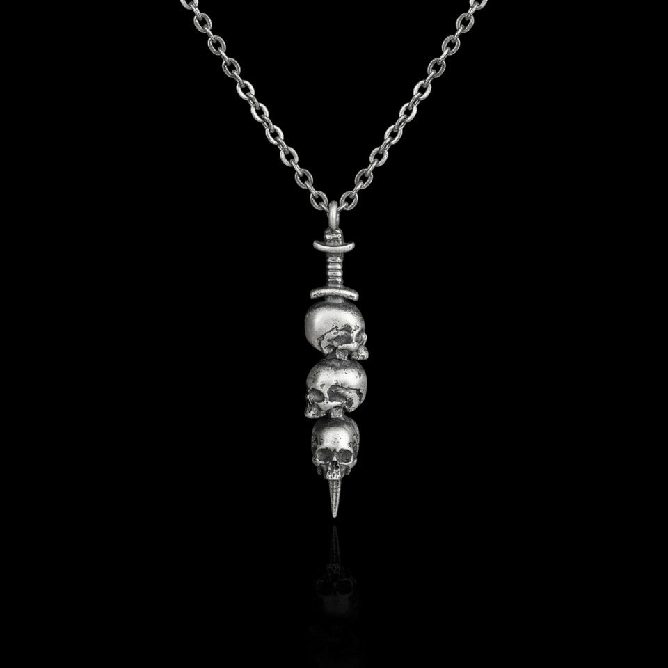 Impaled stainless steel skull and dagger necklace on a black background