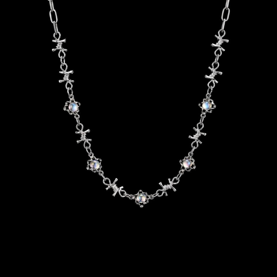 Opal barbed wire stainless steel necklace on a black background