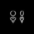 Barbed heart stainless steel hoop earrings on a black background