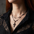 Onyx cross stainless steel necklace on a black background